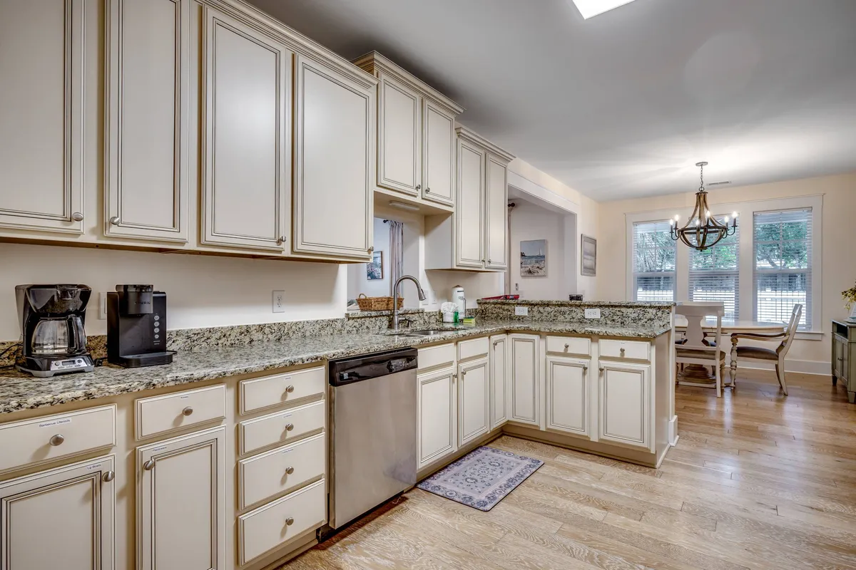 A harmonious space where the granite countertop kitchen flows directly into the dining area, highlighted by modern cabinetry and a stylish light fixture. This setup creates an inviting environment for family meals and social celebrations.